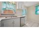 Classic kitchen featuring white cabinets, stainless steel dishwasher, and tile flooring at 600 Federal St, Henderson, NV 89015