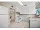 Bright kitchen with white cabinets, white appliances, and an opening to another room at 600 Federal St, Henderson, NV 89015