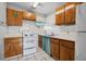 Bright kitchen with wooden cabinetry, white appliances, and tiled floor at 600 Federal St, Henderson, NV 89015