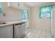 Bright kitchen featuring white cabinets, stainless steel dishwasher, and tile flooring at 600 Federal St, Henderson, NV 89015