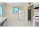 Open kitchen with white appliances, tile flooring, a white refrigerator, and a view into another room at 600 Federal St, Henderson, NV 89015