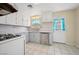 Kitchen featuring white cabinets, white appliances, tile backsplash, stainless steel dishwasher, and a window over the sink at 600 Federal St, Henderson, NV 89015