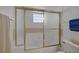 Bright bathroom featuring a shower-tub combination with sliding glass doors and tiled walls at 6804 Elm Creek Dr # 202, Las Vegas, NV 89108