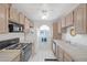 Well-lit kitchen featuring white tile floors, white appliances, and light wood cabinets at 6804 Elm Creek Dr # 202, Las Vegas, NV 89108