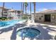 Community pool and spa area with lounge chairs, palm trees, and building views on a sunny day at 6804 Elm Creek Dr # 202, Las Vegas, NV 89108
