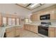 Well-lit kitchen featuring wood cabinetry, tile countertops, and modern appliances at 7232 Vista Bonita Dr, Las Vegas, NV 89149