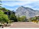 Gated community entrance with desert landscaping, lush trees, and a mountain view at 754 Tallgrass St, Las Vegas, NV 89138