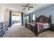 The main bedroom has an ornate bed and dresser, blue walls, and access to a private patio at 754 Tallgrass St, Las Vegas, NV 89138