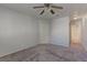 Neutral bedroom featuring carpet, ceiling fan, and a doorway leading to the bathroom at 7968 Lisa Dawn Ave, Las Vegas, NV 89147