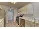 Well-lit kitchen featuring white cabinets, stainless steel appliances, and durable tile flooring at 7968 Lisa Dawn Ave, Las Vegas, NV 89147