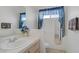 Cozy bathroom featuring blue patterned curtains, tiled countertops, and decorative accents at 8116 Kokoma Dr, Las Vegas, NV 89128