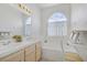 A bright bathroom with double sinks and large arched window above the tub at 8116 Kokoma Dr, Las Vegas, NV 89128