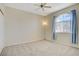 Bedroom with a vaulted window, neutral carpet, and a ceiling fan, offering a comfortable retreat at 8116 Kokoma Dr, Las Vegas, NV 89128