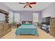 Comfortable bedroom with wood-look flooring, ceiling fan, and lots of natural light from two windows at 8116 Kokoma Dr, Las Vegas, NV 89128