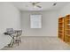 Spacious bedroom with plush carpeting, a ceiling fan, and organized wooden shelving at 8116 Kokoma Dr, Las Vegas, NV 89128