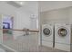 Upstairs laundry area with modern washer and dryer units next to an open living space at 8116 Kokoma Dr, Las Vegas, NV 89128