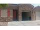 Stone accents adorn this home's facade, complemented by a two-car garage and a red front door at 864 Chianti Way, Mesquite, NV 89027