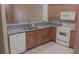 Well-lit kitchen features granite countertops, stainless steel sink, and white appliances at 864 Chianti Way, Mesquite, NV 89027