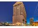 Striking exterior view of a modern high-rise building at night, surrounded by city lights and palm trees at 900 S Las Vegas Blvd # 1208, Las Vegas, NV 89101