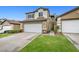Charming two-story townhome with a two-car garage, stone accents, and a well-maintained lawn at 10311 Birch Bluff Lane Ln, Las Vegas, NV 89145