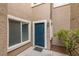 Inviting front entrance features a blue door, tan siding, and a window, offering curb appeal and natural light at 10311 Birch Bluff Lane Ln, Las Vegas, NV 89145