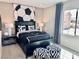 Modern bedroom featuring a black bed set and soccer themed decor at 10376 Joaquin Fire St, Las Vegas, NV 89141