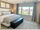 Inviting main bedroom with large window, accent wall, tufted headboard and dark wood storage bench at 10376 Joaquin Fire St, Las Vegas, NV 89141