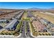 An aerial view of a meticulously planned community showcasing uniform housing, desert landscaping, and mountainous backdrop under a clear sky at 10773 Bede Ct, Las Vegas, NV 89166