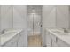 Bathroom featuring double sinks and quartz countertops, with a glass door shower in the center at 10773 Bede Ct, Las Vegas, NV 89166