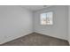 A view of a bedroom with gray carpeting, white walls, and a window that brings in natural light at 10773 Bede Ct, Las Vegas, NV 89166