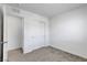 A view of a bedroom with gray carpeting, white walls, closet, and door at 10773 Bede Ct, Las Vegas, NV 89166