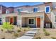 Inviting two-story townhome features an orange front door, low maintenance landscaping, and a concrete walkway at 10773 Bede Ct, Las Vegas, NV 89166
