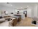 Bright living room with white kitchen, stainless steel appliances, and modern furnishings at 10773 Bede Ct, Las Vegas, NV 89166