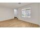 Bright living room area with wood flooring, large window, and light walls at 10773 Bede Ct, Las Vegas, NV 89166