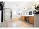 Bright bathroom featuring dual vanity, soaking tub, glass shower and gray wood floors at 11134 Casala Ct, Las Vegas, NV 89141