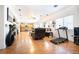 Open-concept living area featuring wood floors and ample space with a treadmill and dark accents at 11134 Casala Ct, Las Vegas, NV 89141