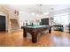 Spacious living room featuring beautiful hardwood floors, stairs and a stylish pool table at 11134 Casala Ct, Las Vegas, NV 89141