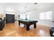 Spacious living room featuring beautiful hardwood floors and a stylish pool table at 11134 Casala Ct, Las Vegas, NV 89141