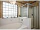 Bright bathroom featuring a white soaking tub and separate glass shower at 11157 Sandy Grove Ave, Las Vegas, NV 89144