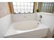 Bright bathroom featuring a white soaking tub and a glass block window at 11157 Sandy Grove Ave, Las Vegas, NV 89144