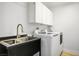 A clean laundry room with sink, modern washer, and dryer at 11157 Sandy Grove Ave, Las Vegas, NV 89144