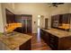 Modern kitchen featuring dark cabinetry, granite countertops, and stainless steel appliances at 185 Camrose St, Henderson, NV 89074
