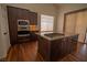 Modern kitchen featuring stainless steel appliances, an island gas cooktop, and granite countertops at 185 Camrose St, Henderson, NV 89074