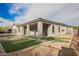 Backyard featuring a covered patio, low maintenance synthetic grass, and a decorative gravel and stone design at 19 Desert Ivy Ln, Henderson, NV 89011