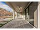 Covered patio with stone pavers and a view of the landscaped backyard with a rock retaining wall at 19 Desert Ivy Ln, Henderson, NV 89011