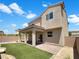 Backyard showcases artificial turf, a covered patio, and a neutral-toned two-story home at 2125 Stone Well Rd, North Las Vegas, NV 89031