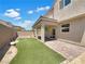 This backyard features artificial turf and a covered patio area with brick pavers at 2125 Stone Well Rd, North Las Vegas, NV 89031