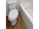 The well-lit bathroom features a pristine white toilet, bathtub, and wood-style floors at 2125 Stone Well Rd, North Las Vegas, NV 89031