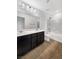 Clean bathroom with dark wood cabinets, double vanity sinks, and a bathtub and shower combination at 2125 Stone Well Rd, North Las Vegas, NV 89031