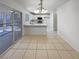 Open-concept dining room featuring tile floors and a view of the modern white kitchen at 2125 Stone Well Rd, North Las Vegas, NV 89031